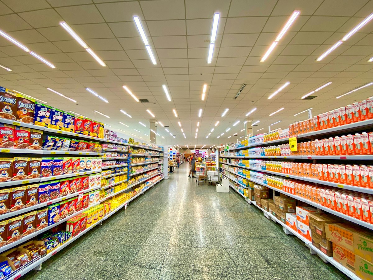 Bright, clean convenience store aisles stocked with snacks and drinks
